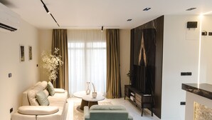 Una sala de estar moderna con un sofá, una mesa de centro y un televisor.