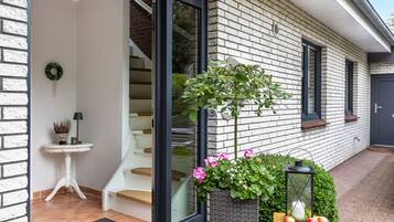 Een modern huis met een trap, een kleine tafel met een lamp en een bloemenplanter.