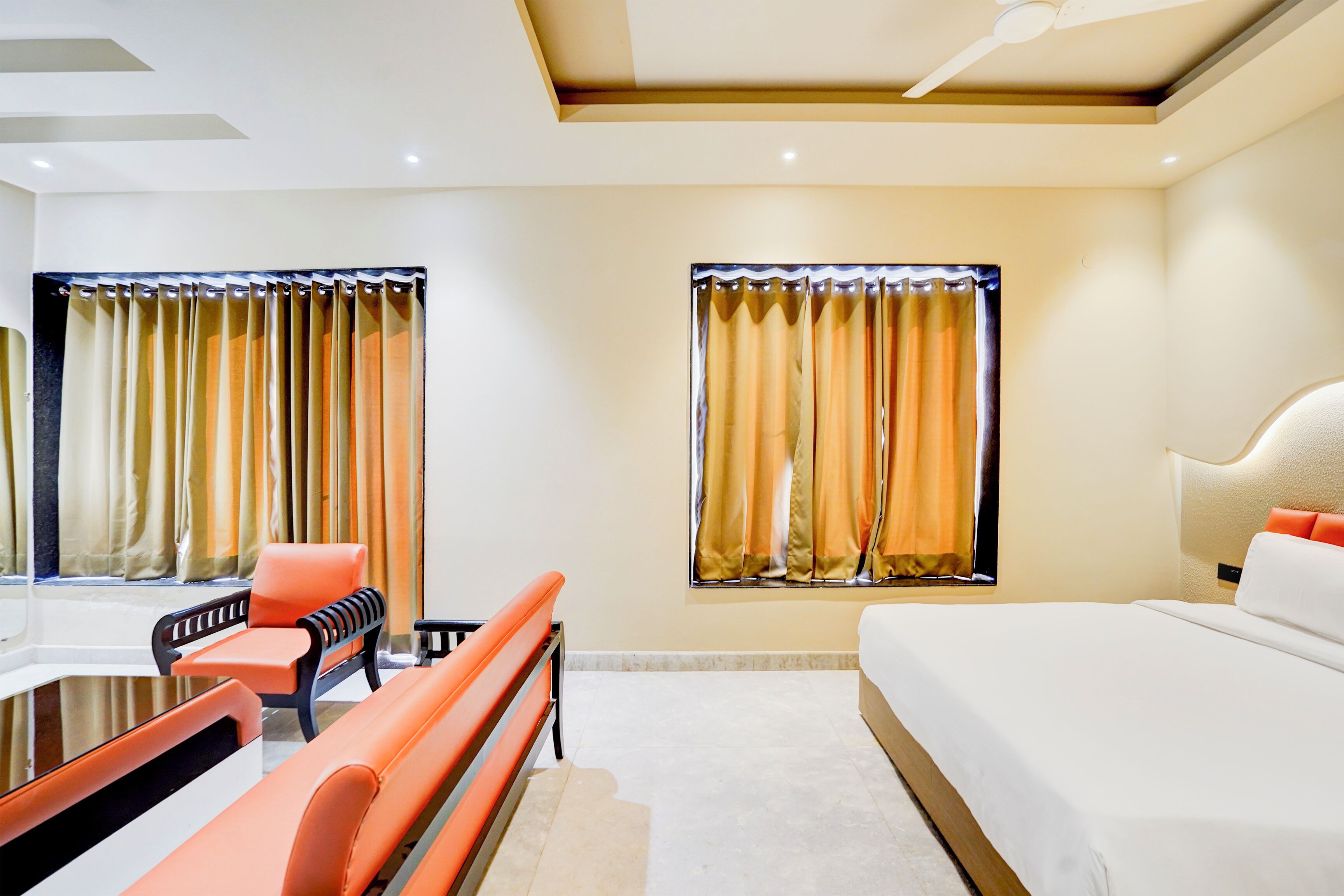 A hotel room with a bed, a desk, and two chairs.