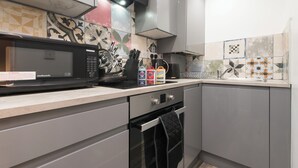 A kitchen with a microwave, oven, and various kitchen utensils. - Tranquil Derby 2 Bedroom Apartment Retreat (Derby)