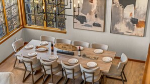 Un'area pranzo con un tavolo di legno apparecchiato per sei persone, circondato da sei sedie.