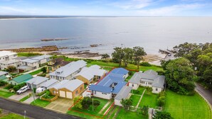 Uma área residencial costeira com casas, uma praia e um litoral rochoso.