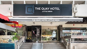 L’entrée de l’hôtel The Quay Hotel Little India, avec un panneau indicateur, un escalier et une rampe pour faciliter l’accès aux personnes à mobilité réduite.