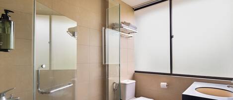 A modern bathroom with a glass shower enclosure, a white toilet, and a black sink.