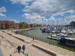 A marina with boats docked, a pedestrian walkway, and buildings in the background. - Cosy 1Bed Getaway in Central Hull (Hull)