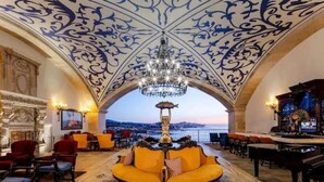 A luxurious lobby with a grand chandelier, a central sofa, and a view of the cityscape through an arched doorway. - Charming ocean front 3-bdm  Cabo San Lucas, plunge pools  roof top pool and spa. (Cabo san Lucas)