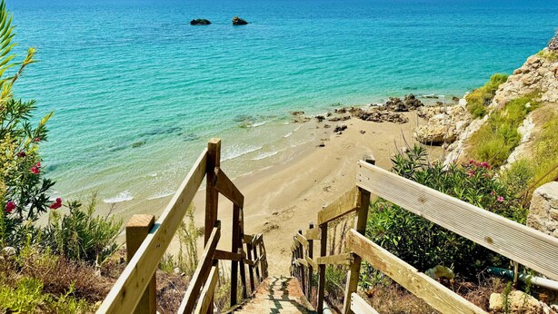 A wooden staircase leading down to a beach with clear turquoise water and rocky outcrops. - Beachfront Villa Rania with private pool (Chalikounas)