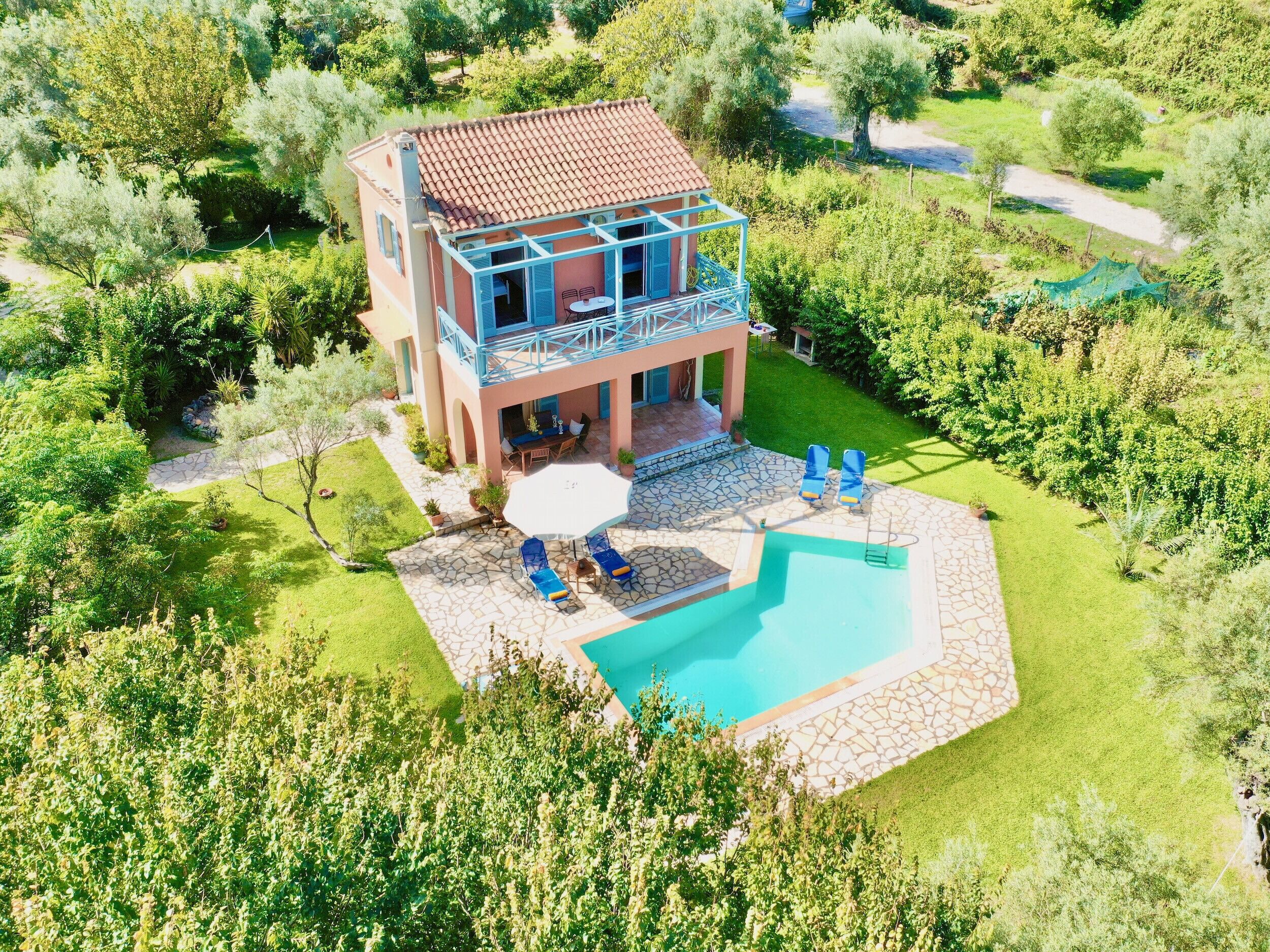A two-story house with a swimming pool, outdoor seating, and a garden.