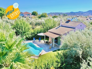 Propiedad residencial con piscina, patio y follaje circundante.