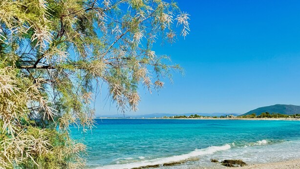 A beach with clear turquoise water, pebbly shore, and distant mountains. - Beach Villa Fotini with private pool (Lefkada)