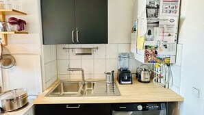 A compact kitchen with a dishwasher, a sink, and a built-in washing machine. - Charming townhome with 2 bedrooms and AC, WiFi in lovely Suffolk Park (Suffolk Park)