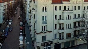 A street view with a row of buildings, including a prominent building with a sign reading "SANITÄTSHAUS MORSCHKE". - Charming townhome with 2 bedrooms and AC, WiFi in lovely Suffolk Park (Suffolk Park)