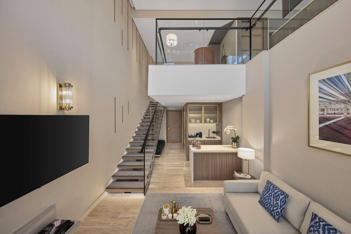 A modern interior with a staircase, a living area, and a kitchen.