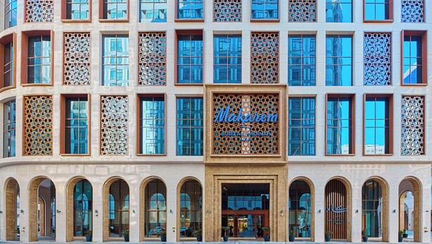 A modern building with a large sign reading "Makarem." It features multiple windows with intricate designs and a series of arched doorways. - Makarem Burj Al Madinah Hotel and Suites (Madinah)
