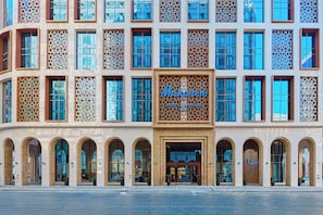 A modern building with a large sign reading "Makarem." It features multiple windows with intricate designs and a series of arched doorways. - Makarem Burj Al Madinah Hotel and Suites (Madinah)