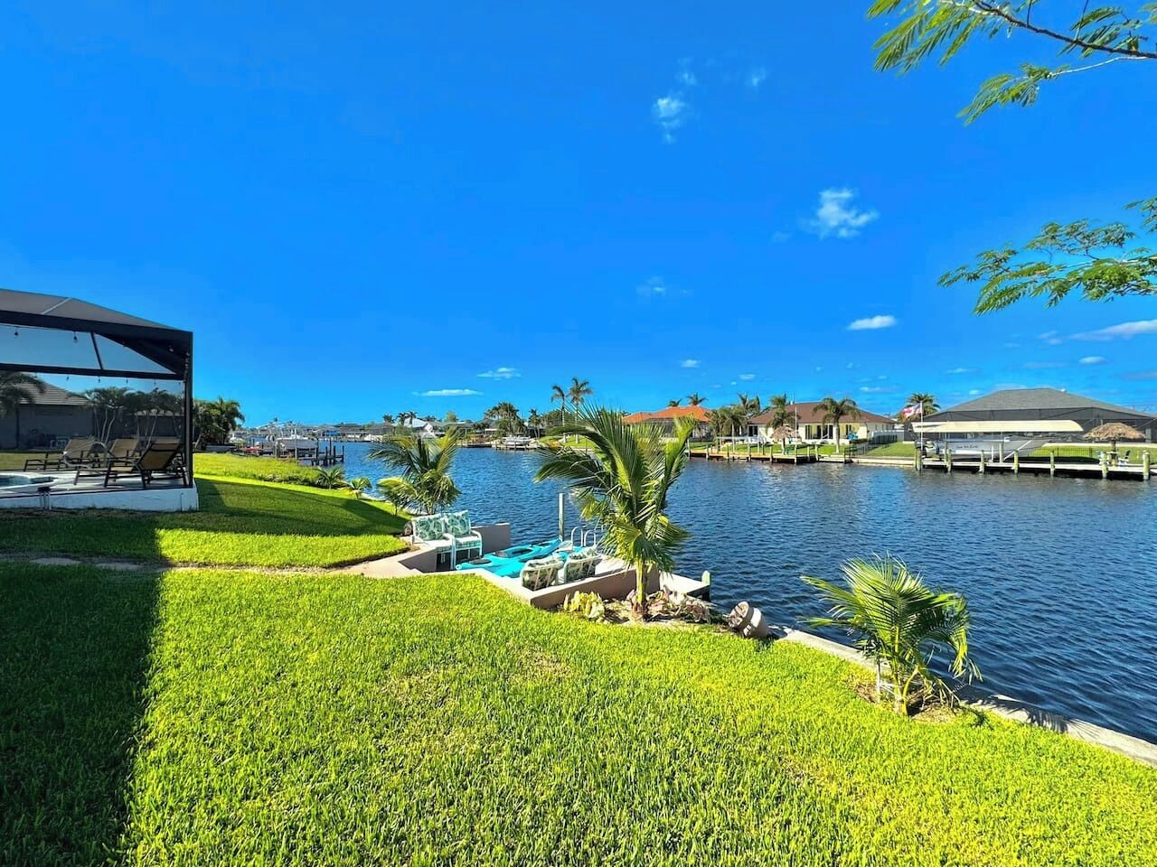 A waterfront property with a pool, lounge chairs, and a view of the water.