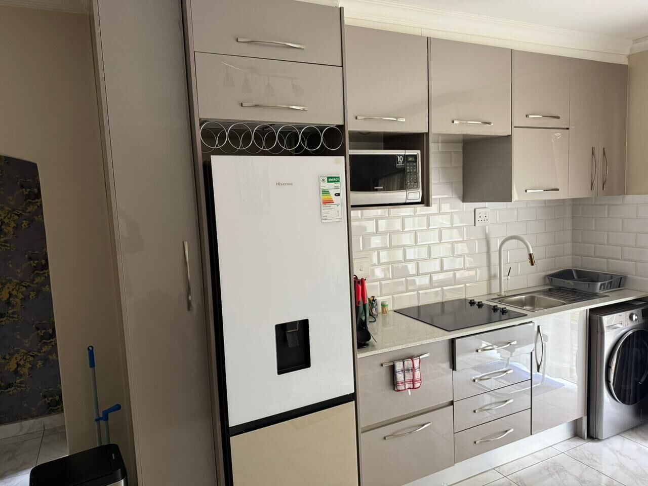 A modern kitchen with a built-in microwave, stainless steel appliances, and a dishwasher.