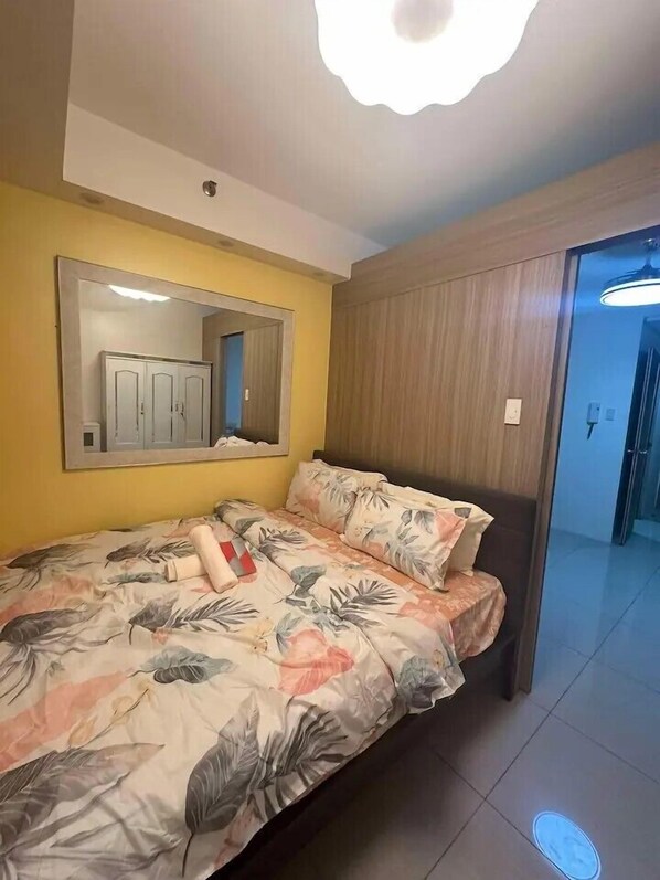 A bedroom with a bed, a mirror, and a wardrobe. - House of Wu (Pasay)