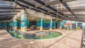 An indoor swimming pool with a tiled floor, a diving area, and a covered section with a glass roof. - Compass Cove Resort Unit 662 - Oceanfront (Myrtle Beach)