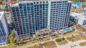 A high-rise hotel with multiple balconies, a pool area, and a beachside location. - Compass Cove Resort Unit 662 - Oceanfront (Myrtle Beach)