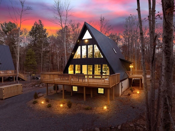 Situated in a wooded area, this cabin offers a tranquil retreat with a spacious deck and seating.