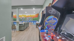 Um quarto com mesa de futebol, área de bar e um mural com a palavra 'POCONOS'.