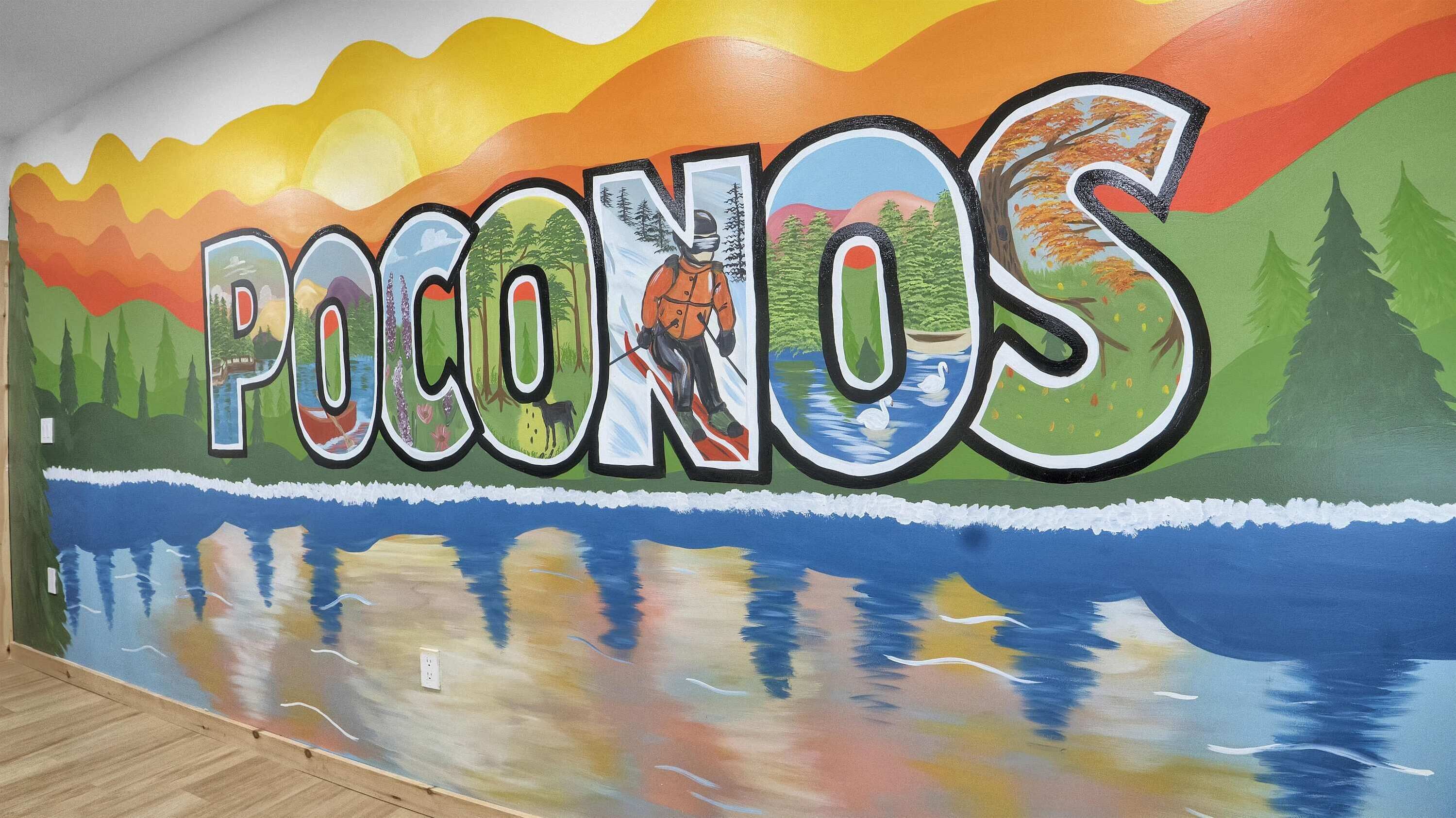 Een muurschildering met het woord 'POCONOS' en een landschapsvoorstelling.