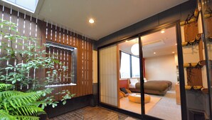 A modern interior with a sliding glass door leading to a living area with a sofa and cushions.