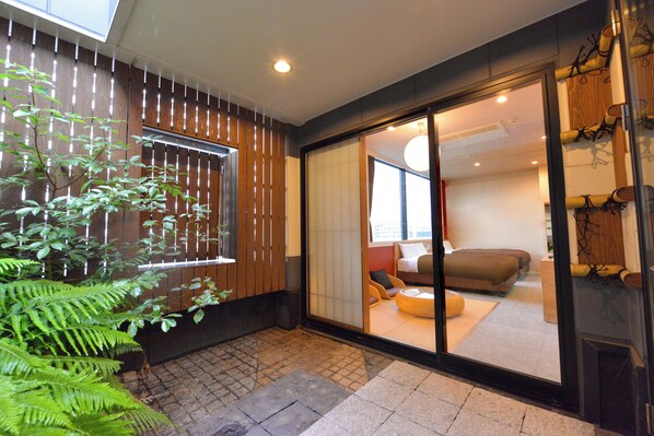 A modern interior with a sliding glass door leading to a living area with a sofa and cushions. - Hotel New Gaea Hakata Messeminami (Fukuoka)