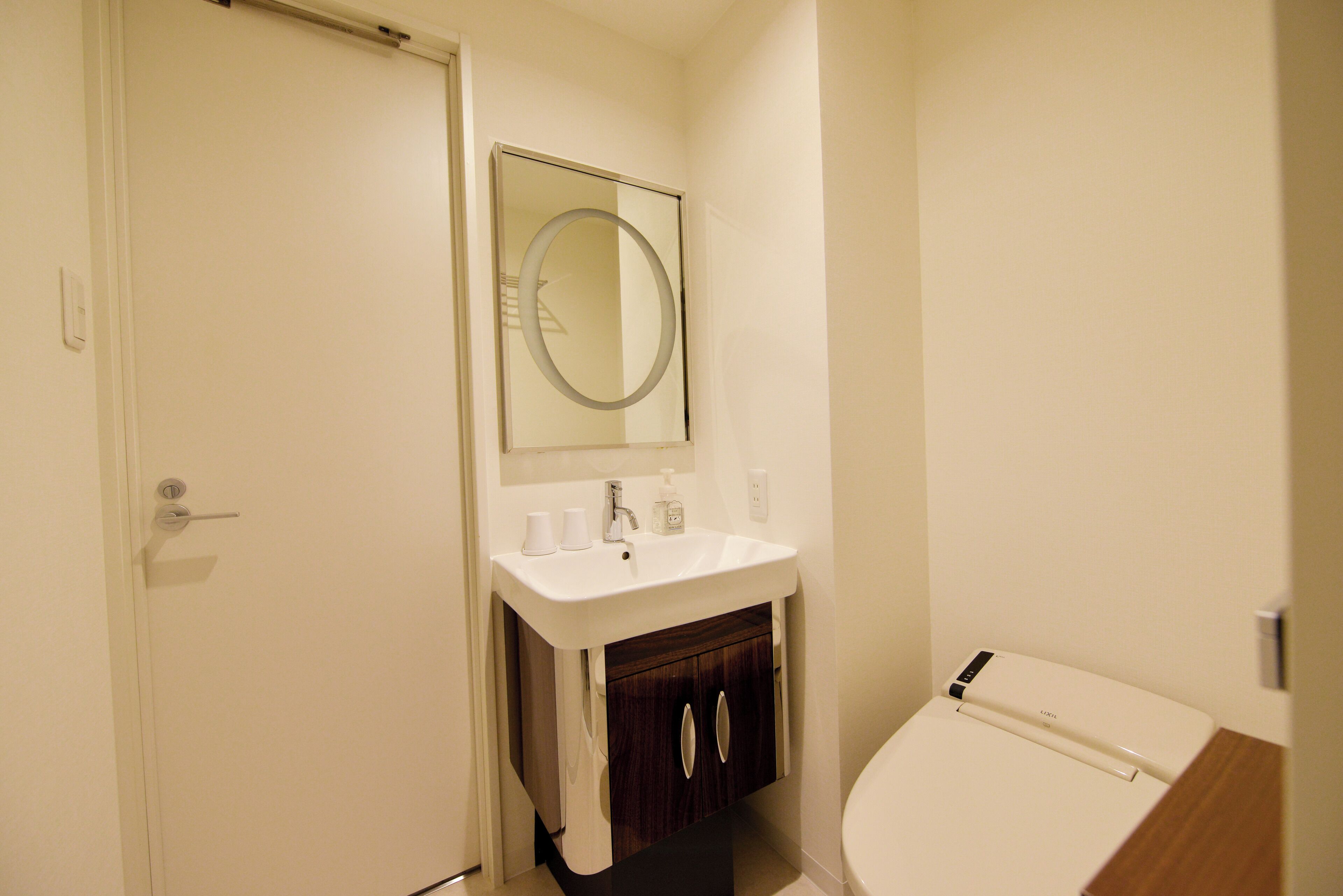 A bathroom with a white sink, a mirror, and a toilet.