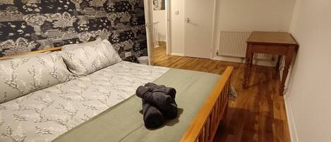 Une chambre à coucher avec un lit, une table en bois et un mur décoré de motifs.