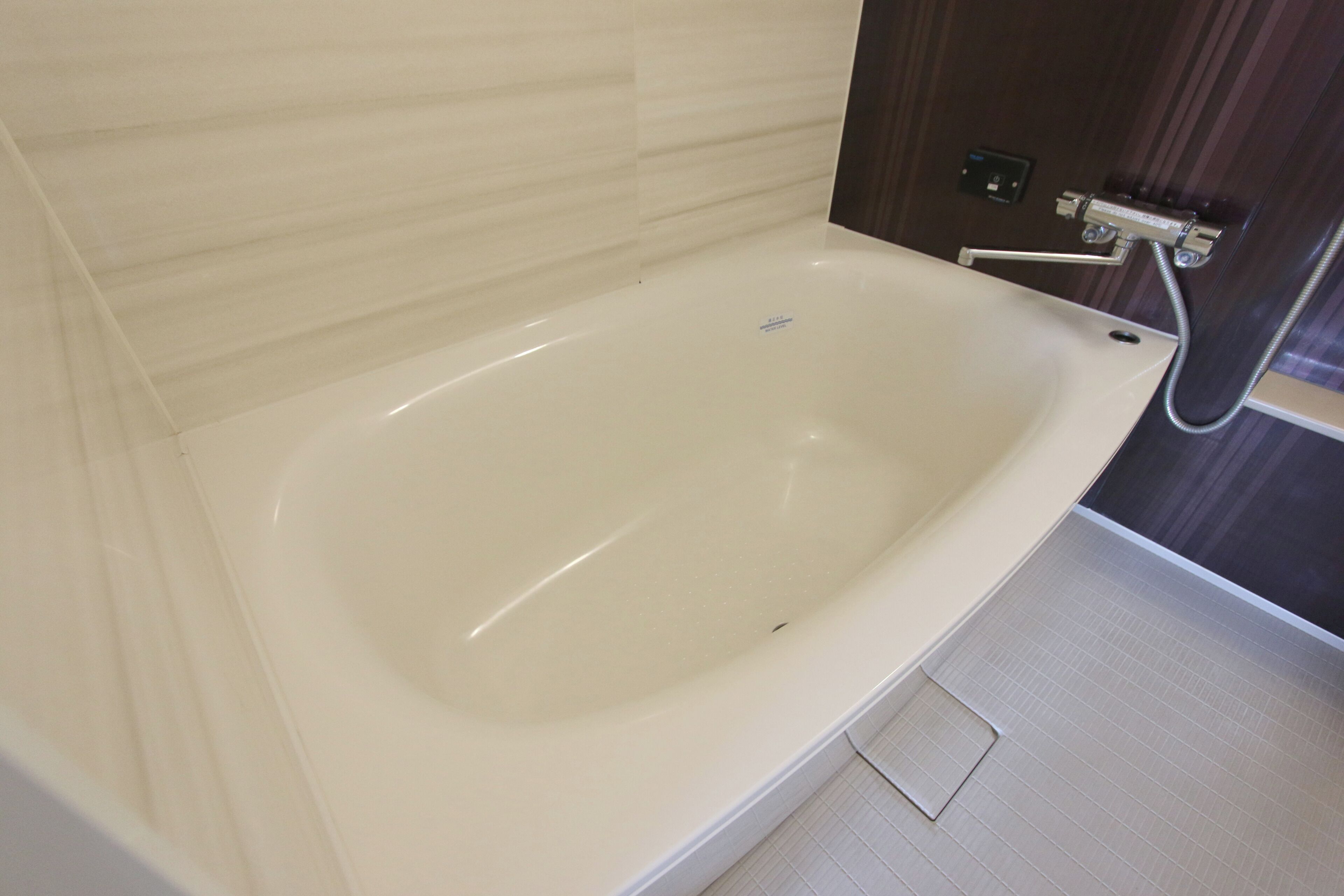 Un baño moderno con una bañera grande, un cabezal de ducha y un panel de control.