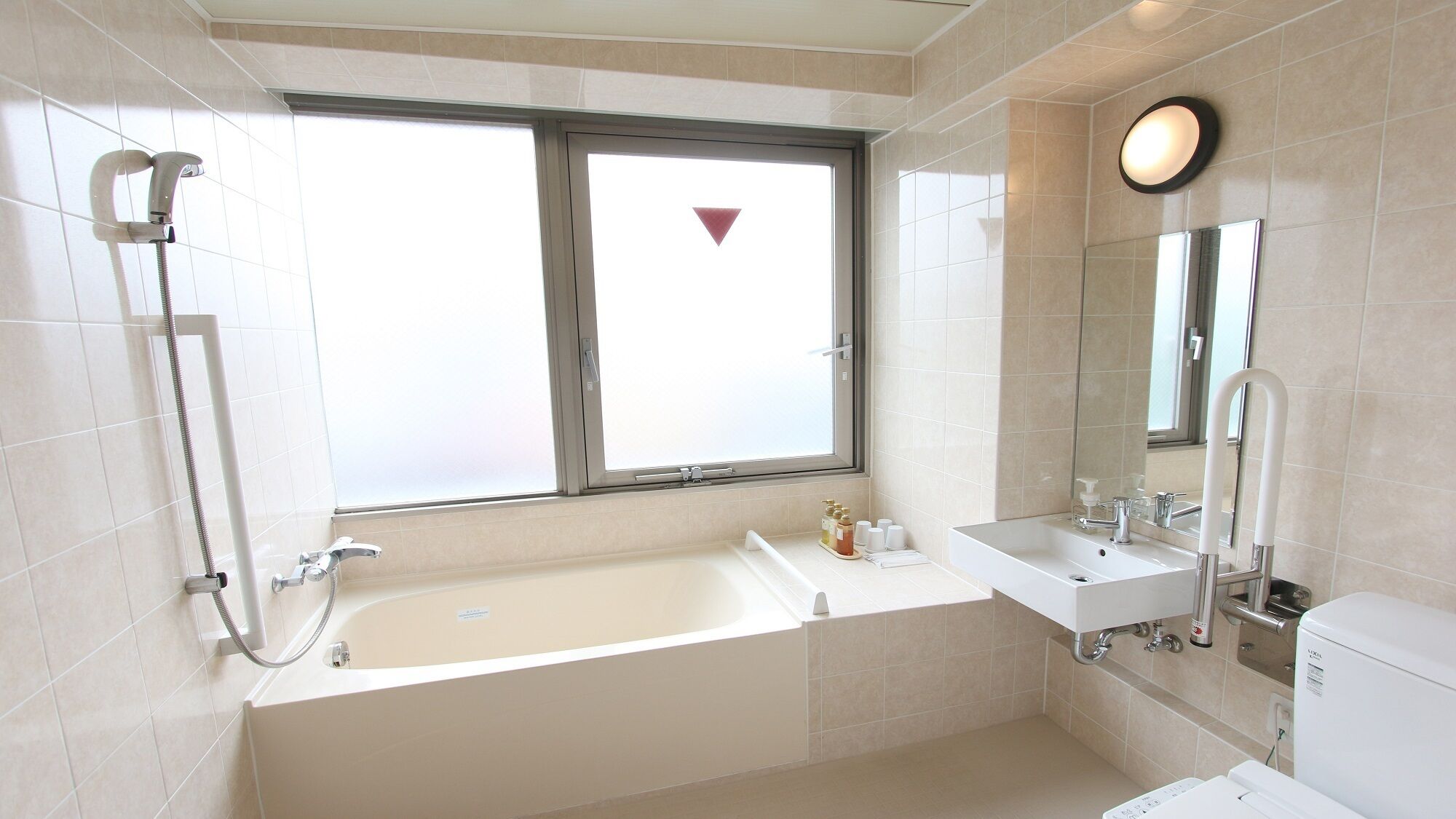 A modern bathroom with a bathtub, a shower, a sink, and a toilet.