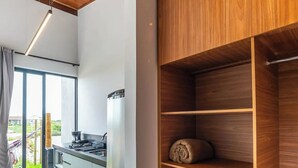 Eine moderne Küche mit Einbauherd, großem Fenster und einer Holzwandregal.