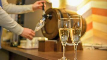 Een bar met twee champagneglazen en een persoon die van de tap schenkt.