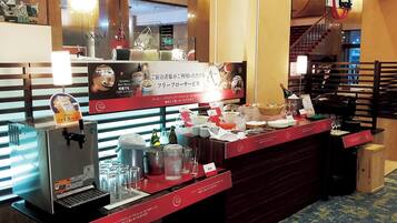 A hotel reception area with a coffee machine, glassware, and a buffet counter.