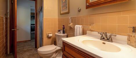 A bathroom with a toilet, sink, and mirror.