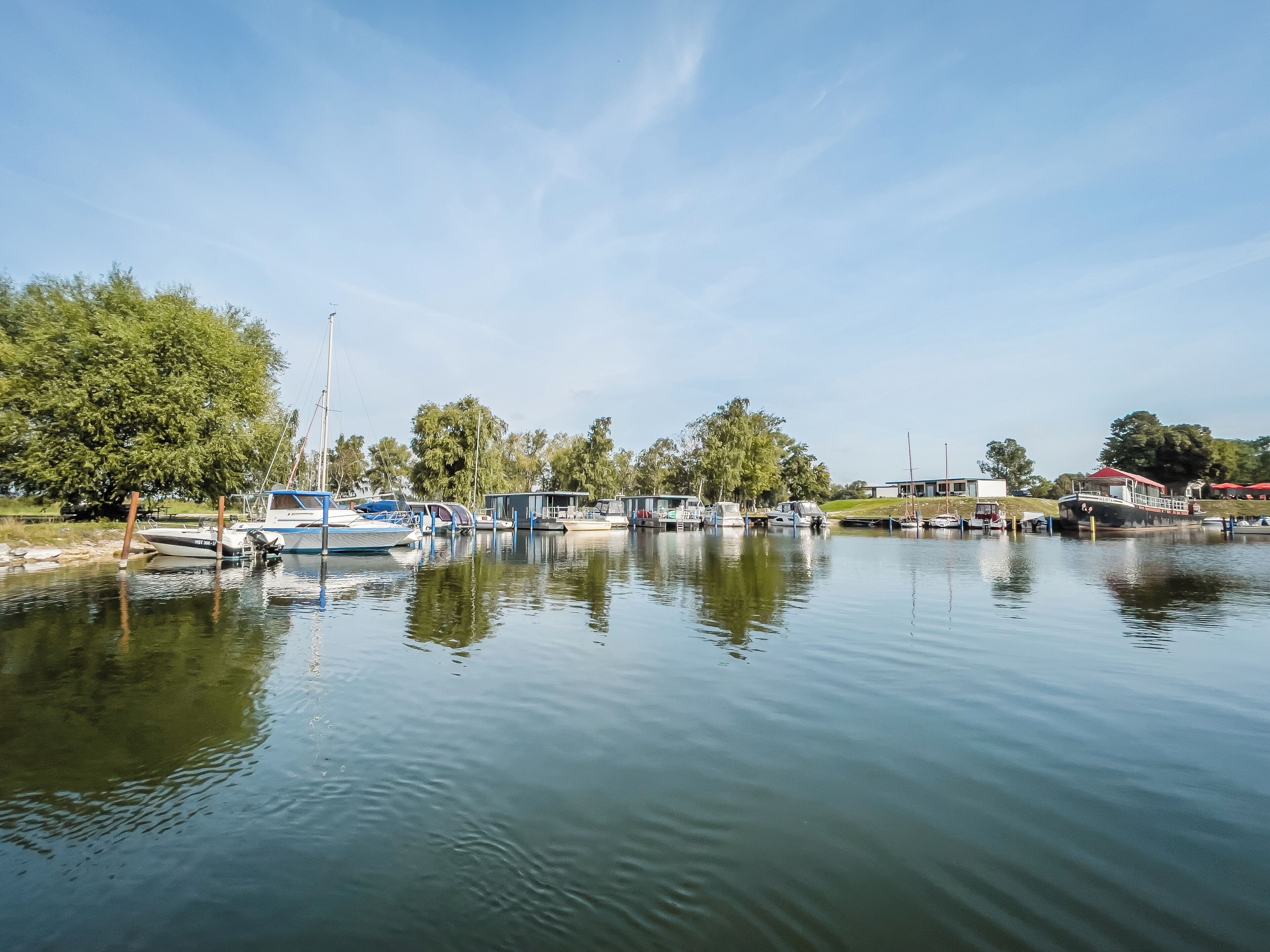 A calm lake with several boats docked along the shore.