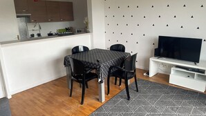 Een knus woongedeelte met een eethoek, een keuken en een televisie.