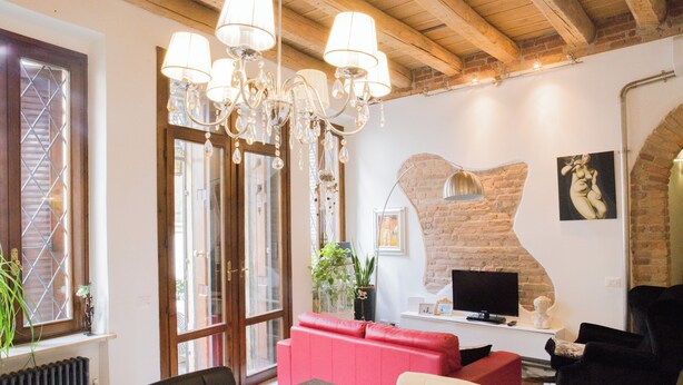 A modern living room with a red sofa, a dining table, and a TV.