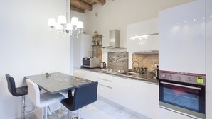 A modern kitchen with a marble countertop, stainless steel appliances, and a built-in oven.