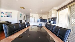 A modern kitchen with white cabinets, a black countertop, and stainless steel appliances. - St Albans House - Spacious and Modern Home (St. Albans)
