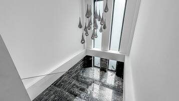 A modern interior with a marble floor, a hanging light fixture, and a window with a view.