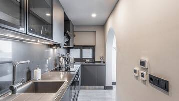 Una cucina moderna con elettrodomestici in acciaio inossidabile, forno integrato e un'ampia isola con lavello.