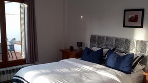 Une chambre à coucher avec un lit, une tête de lit en bois et une table de chevet.