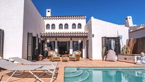 Une villa dotée d’une piscine, d’un espace extérieur aménagé et d’un style architectural traditionnel.