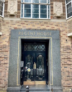 A building entrance with a black door, "RECENT HOUSE" sign, and decorative stonework. - Royal Pavilion Garden Apartment with Parking (Brighton and Hove)