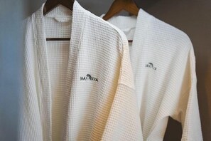 Two white robes hanging on a wooden hanger. - Baan Naya U-tapao (Ban Chang)