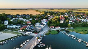 An aerial view of a coastal town with a marina, houses, and a church. - Living with a harbor view—200 meters from the South Beach on the island of Rügen (Altefähr)