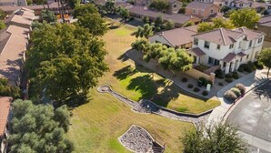 A residential area with houses, a central grassy area, and a paved walkway. - 4-bedroom, 3 Bath Home in Gilbert—Pets Welcome  (Gilbert)